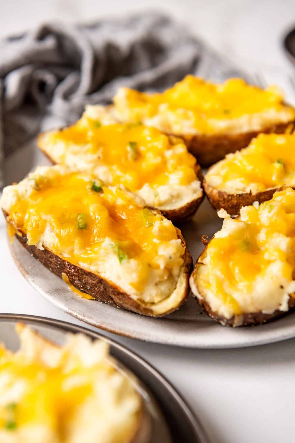 A side view of twice baked potatoes on a serving plate.