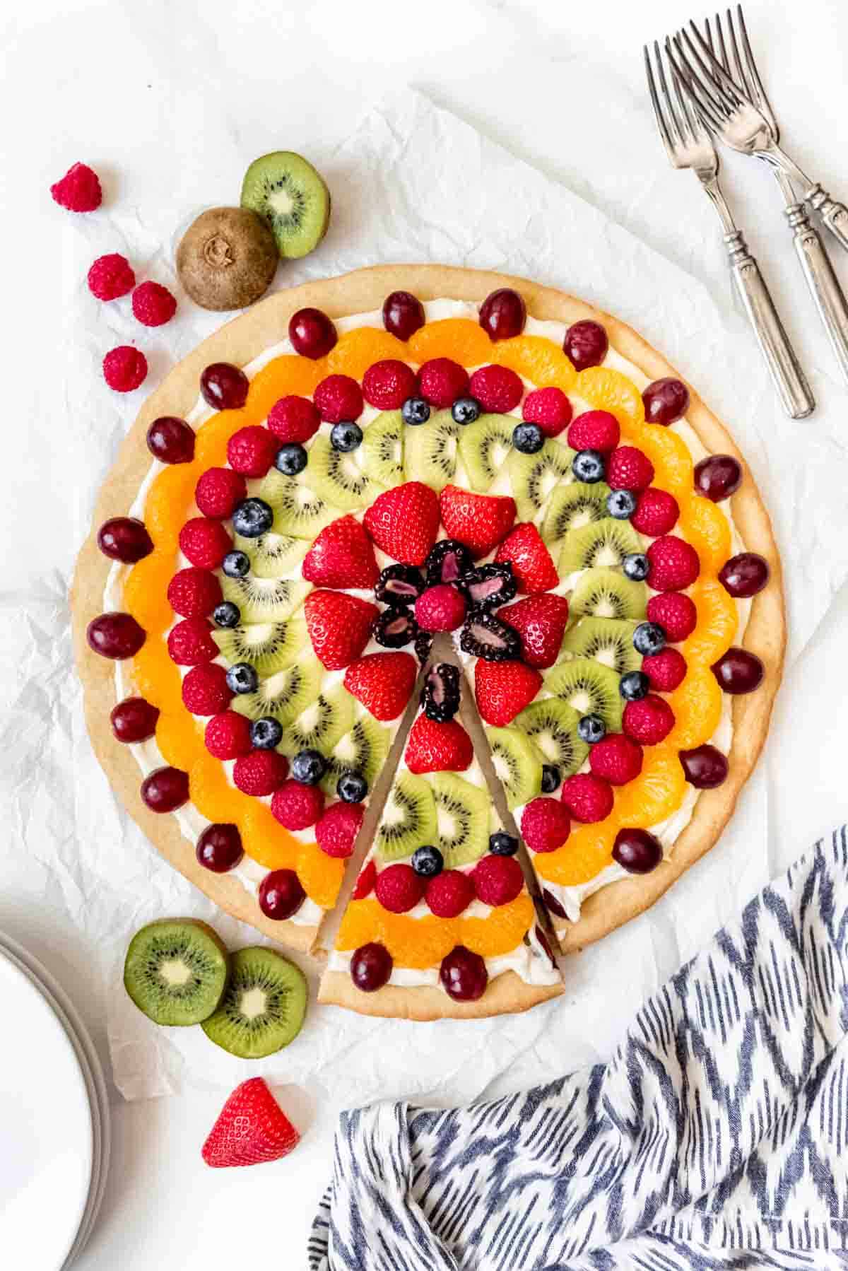 An image of a fruit pizza with one slice removed.