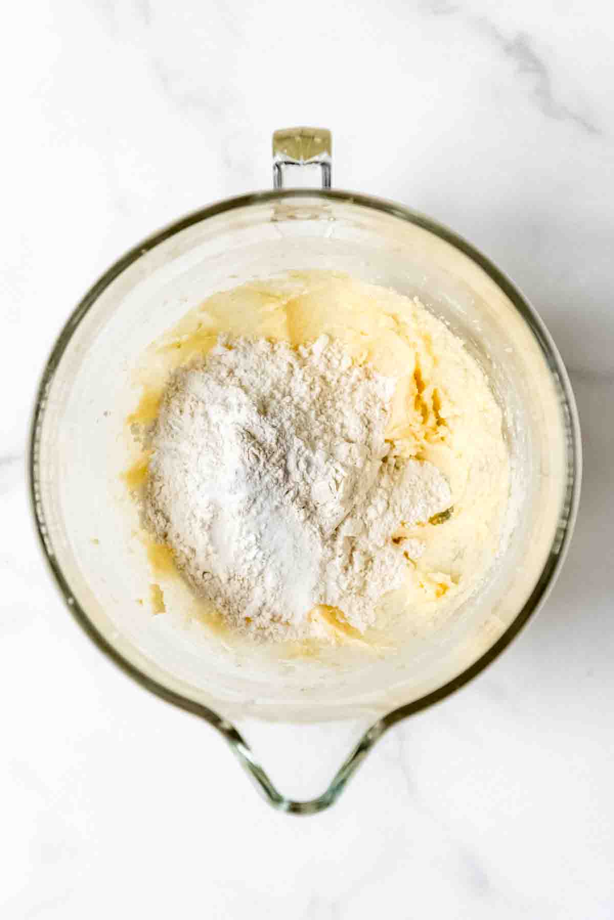 Adding dry ingredients to wet ingredients in a bowl.