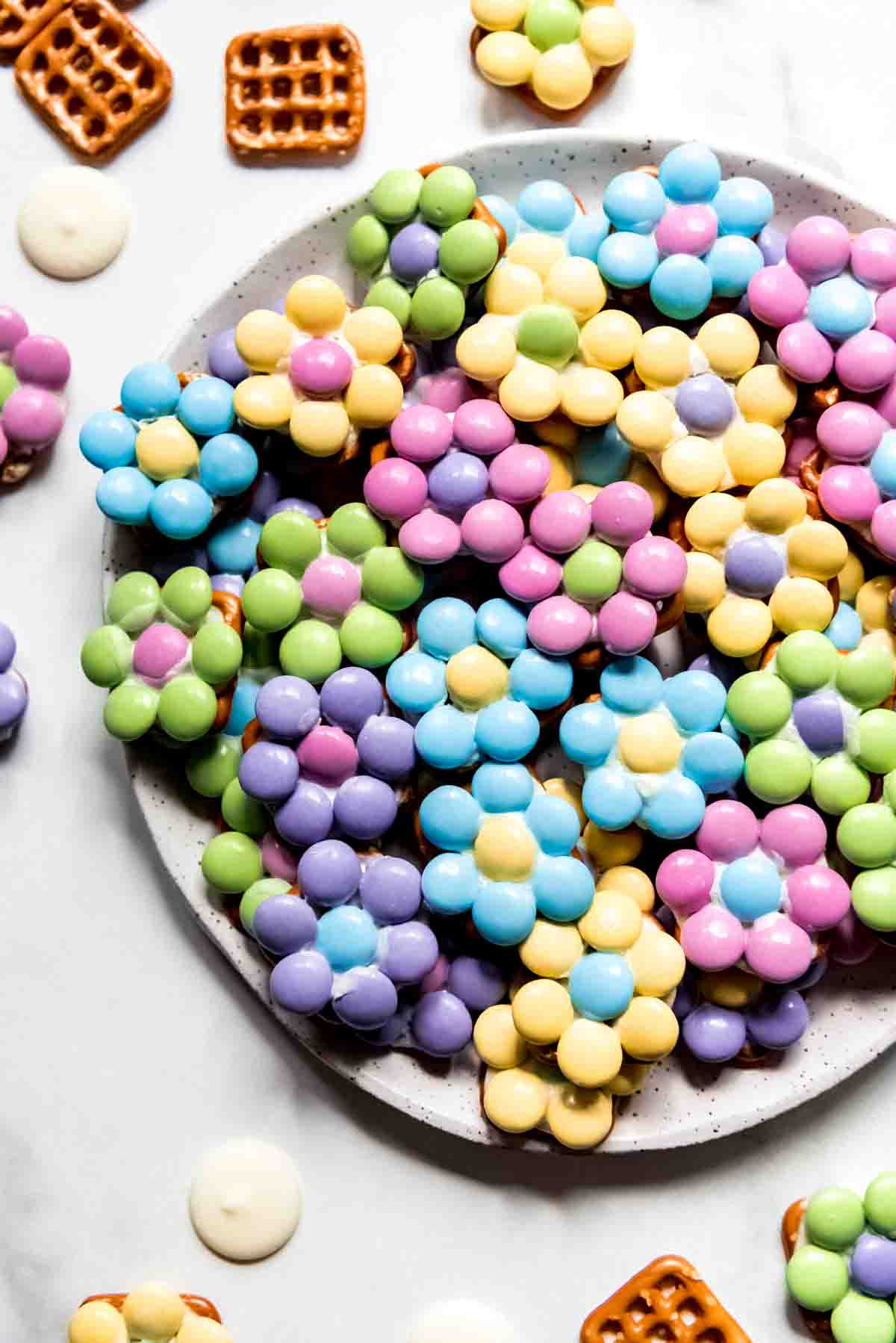 An image of Easter flower pretzel bites in pastel colors on a plate.