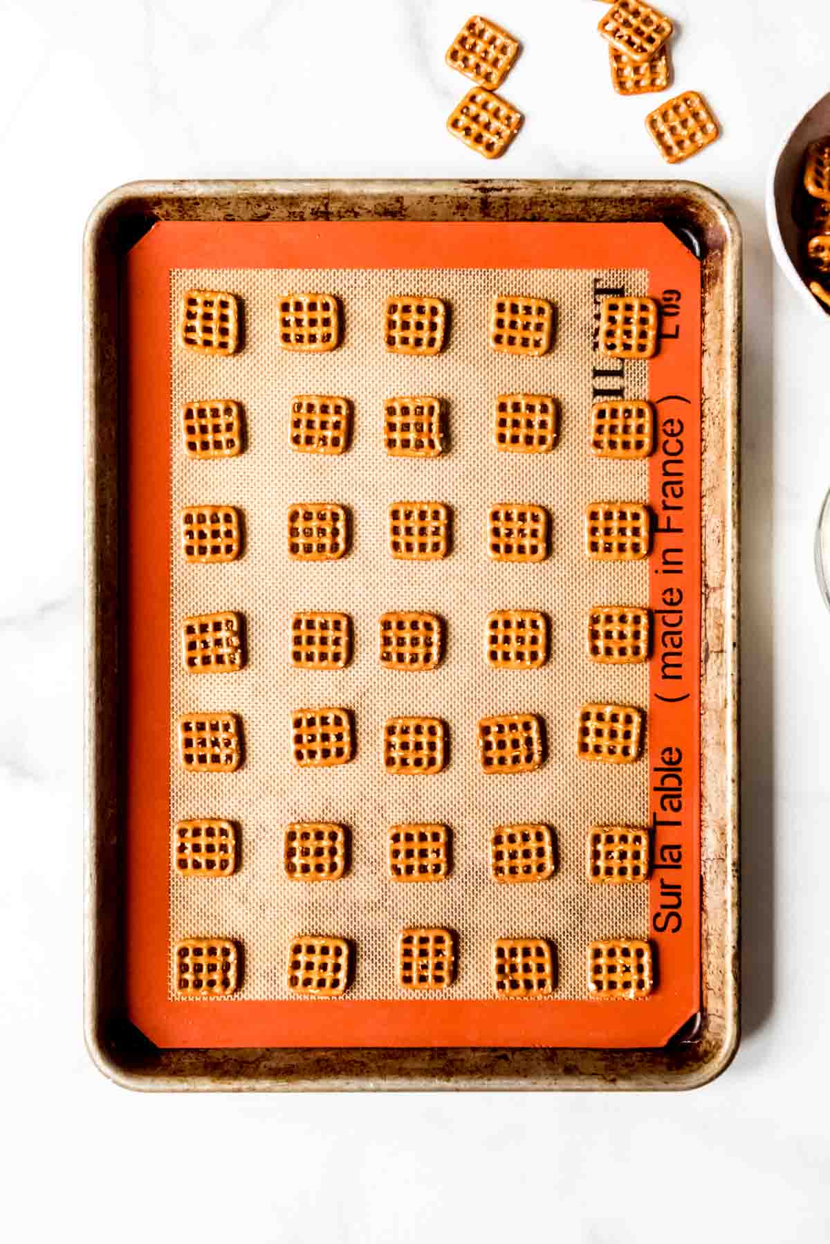 Square pretzel bites on a baking sheet lined with a silpat mat.