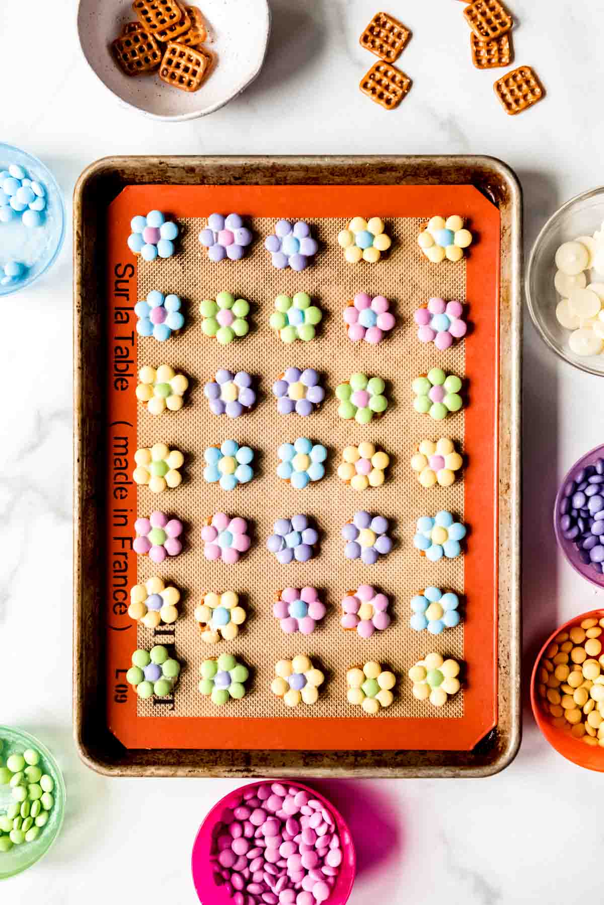 Finished pretzel flower hugs on a baking sheet.