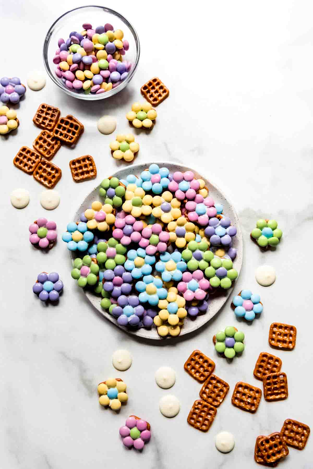 An image of Spring flower pretzel bites on a plate with ingredients around them.