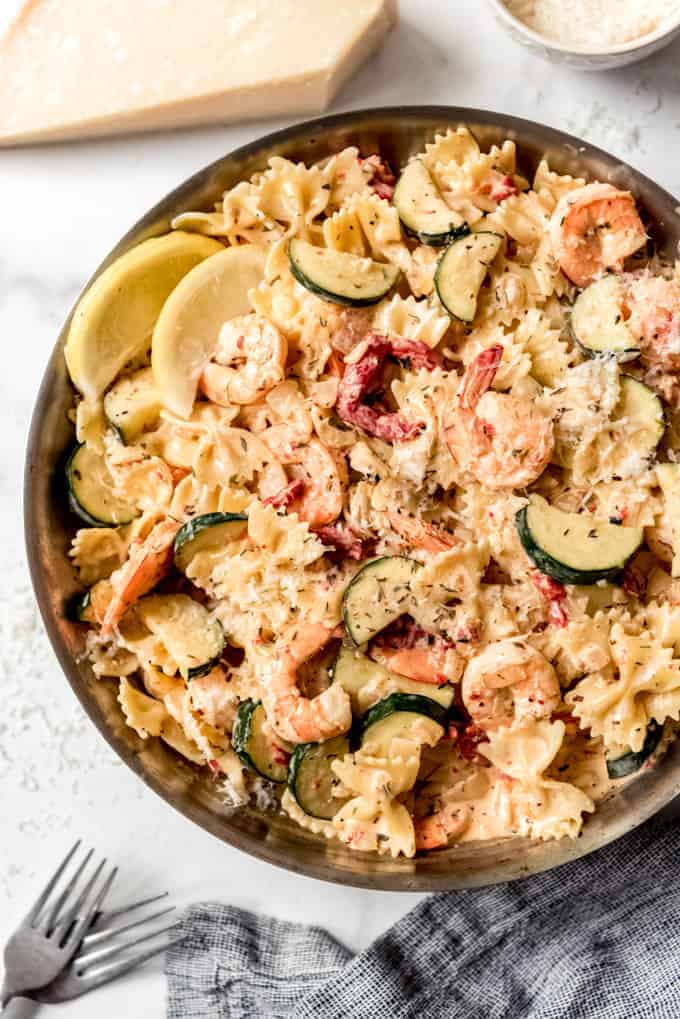 Bowtie pasta with shrimp and vegetables in a creamy sauce in a pan.