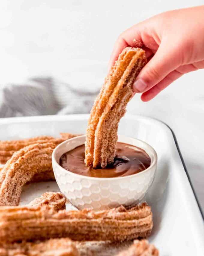 An image of copycat Disneyland churros being dipped in Nutella.