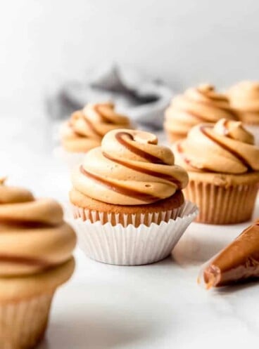 Cupcakes with frosting piped on top with swirls of dulce de leche.