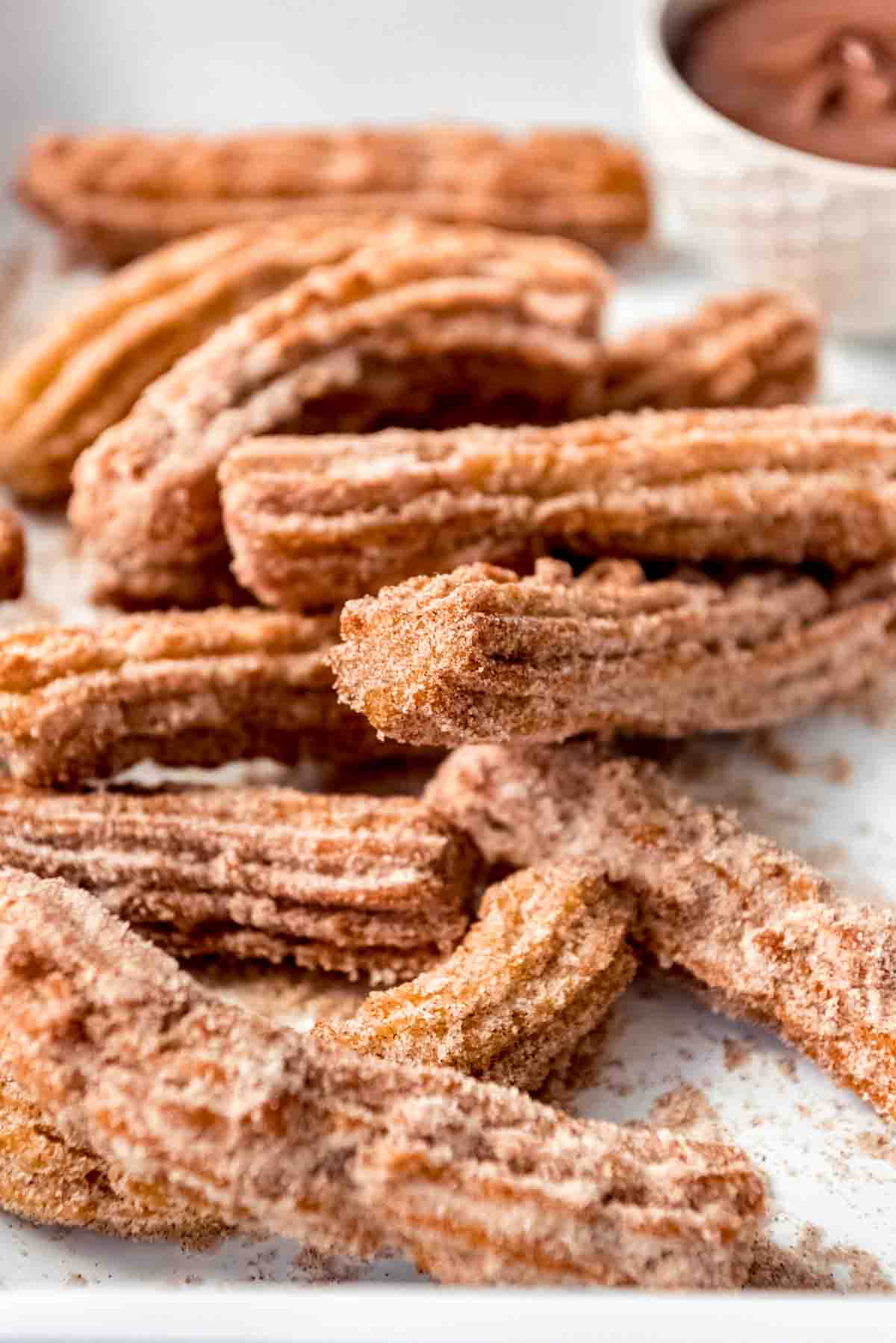 Cinnamon-sugar Mexican donuts piled on a plate.