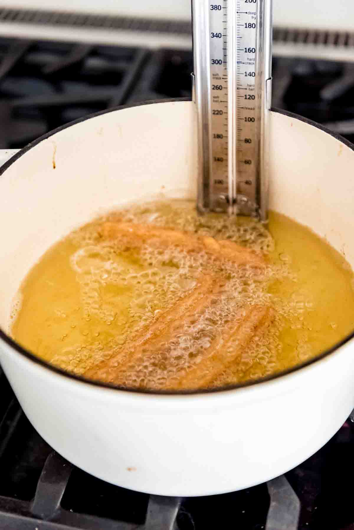 Cooking churros in hot oil in a dutch oven.