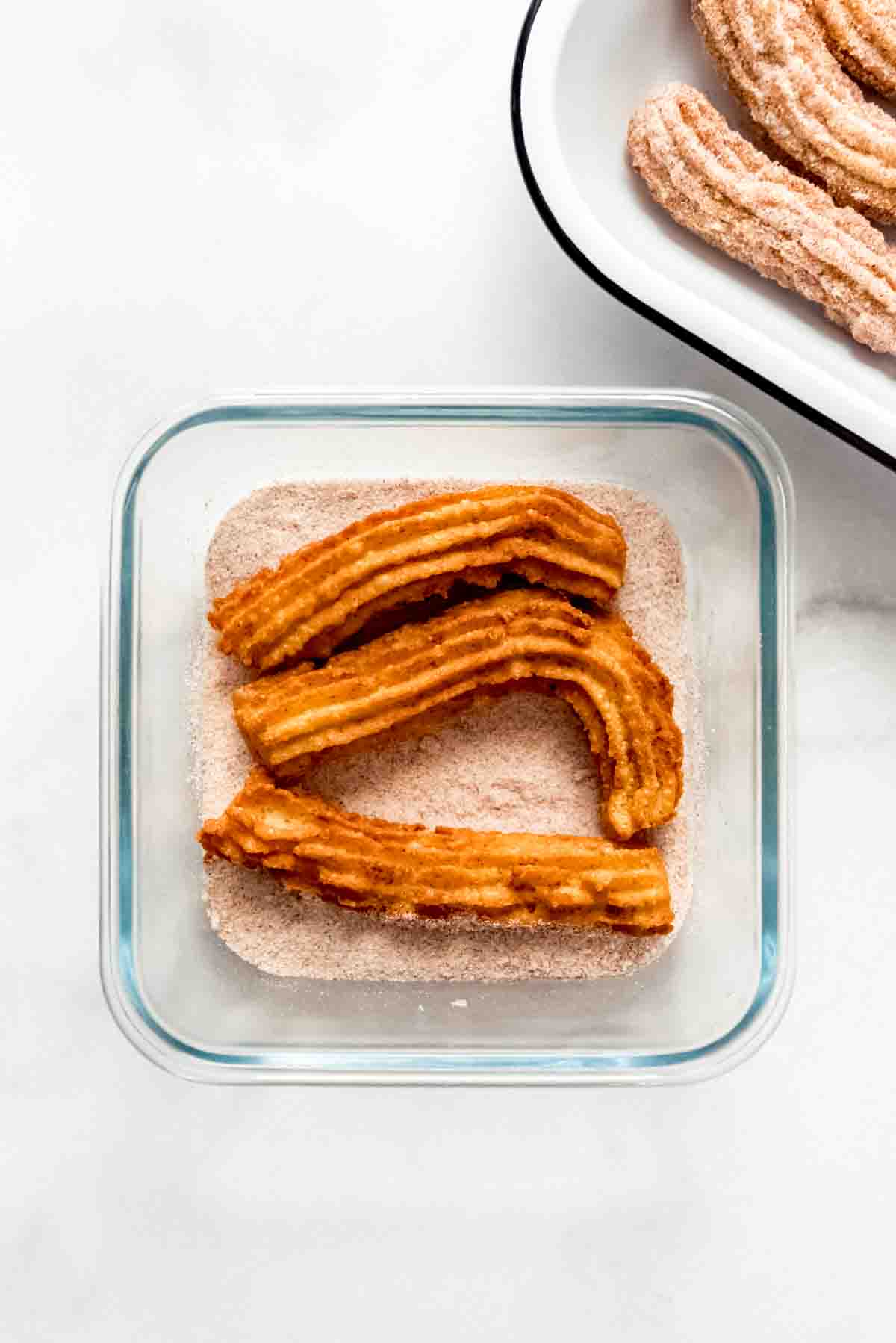 An image of fried churros in cinnamon and sugar .