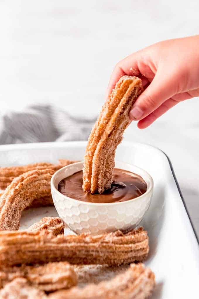 An image of copycat Disneyland churros being dipped in Nutella.