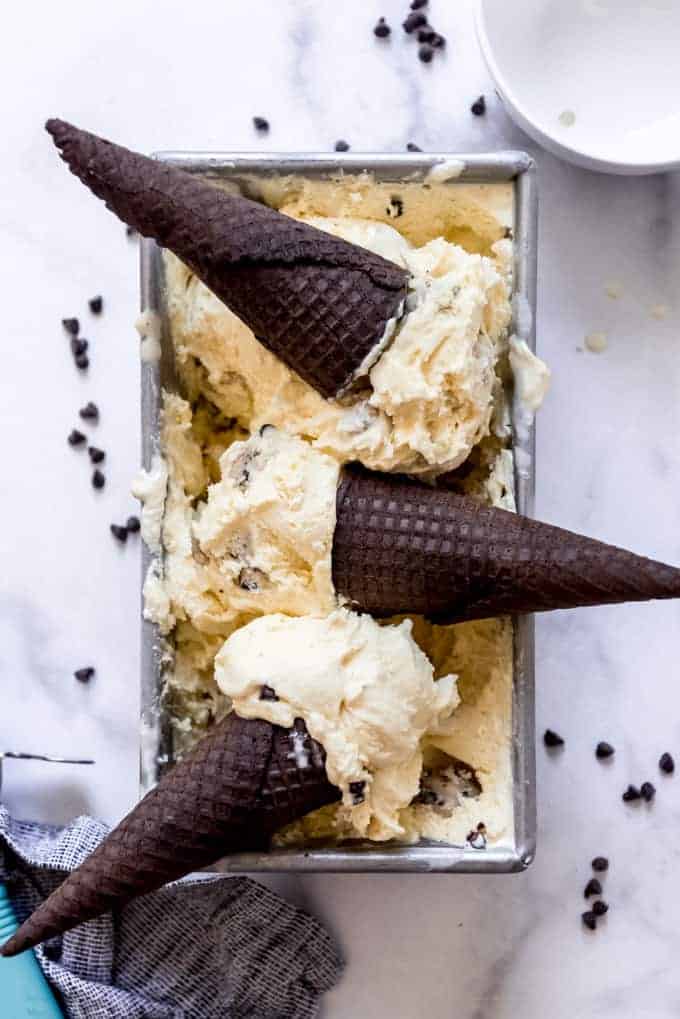 A pan with cookie dough ice cream  scoops and chocolate Oreo cones.