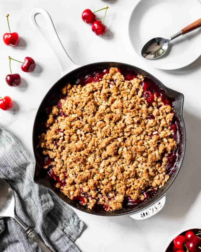 Cherry crisp made in a large cast iron skillet.