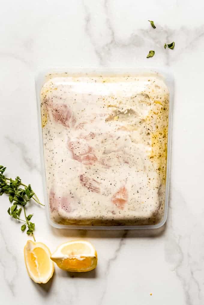 A reusable silicon bag filled with chicken breasts in a greek yogurt marinade.