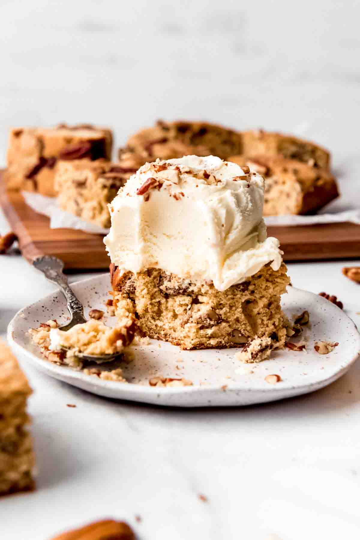 A maple walnut blondie topped with a scoop of vanilla ice cream.