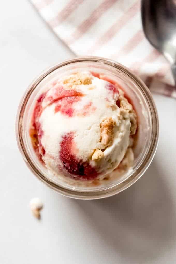 A glass dish with a scoop of rhubarb crumble ice cream in it.