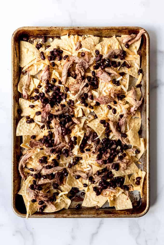 black beans, pulled pork, and cheese on tortilla chips