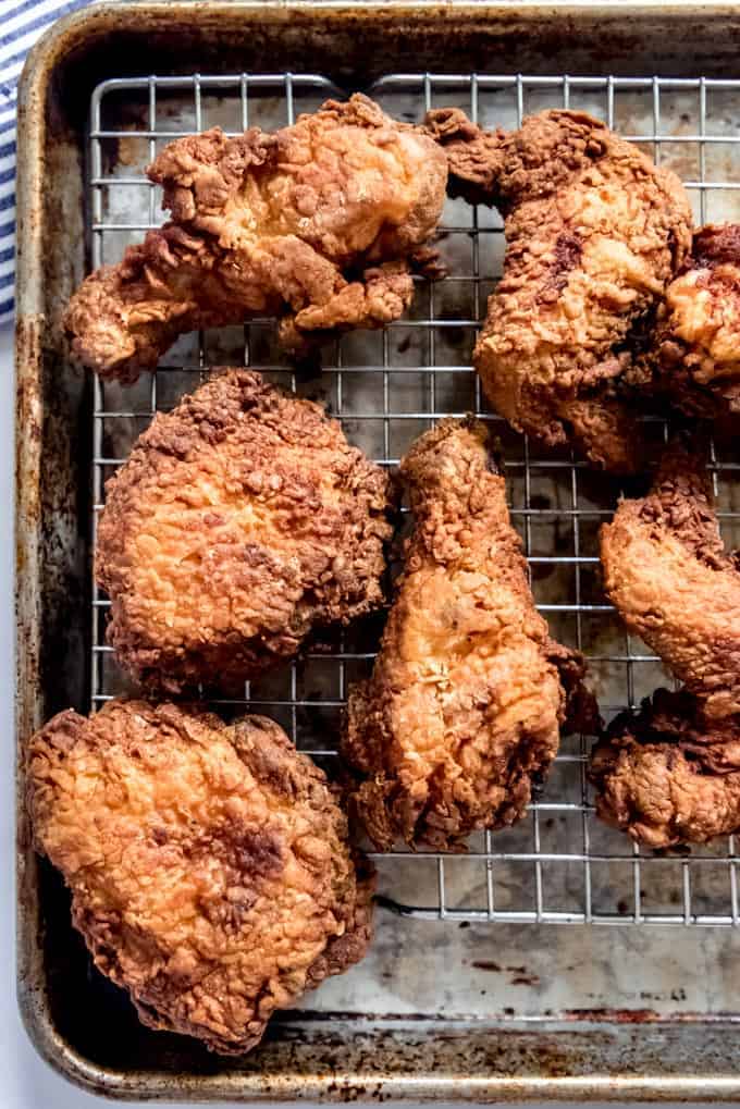 Fried chicken on a wire rack over a baking sheet.