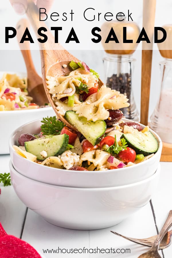 An image of a spoonful of Greek pasta salad held over white bowls with text overlay.