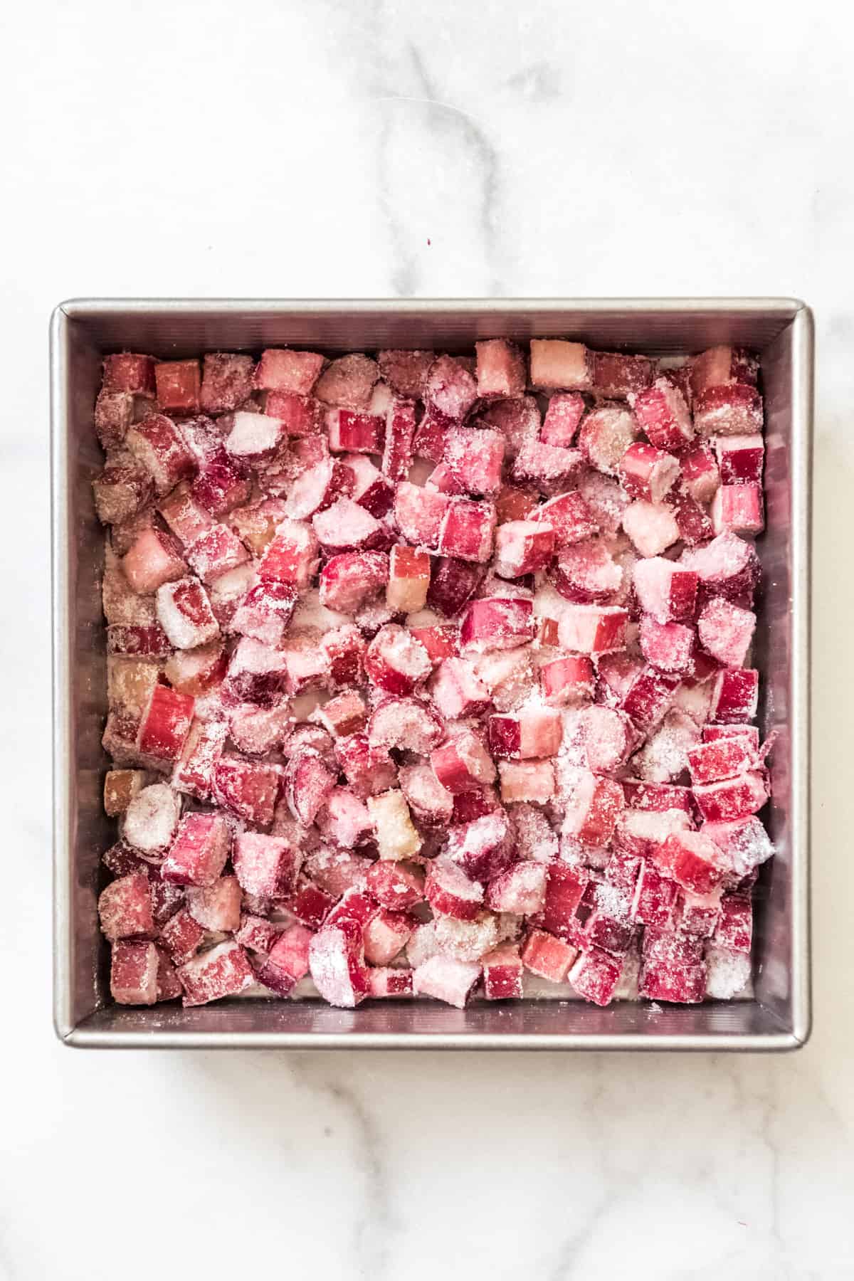 a baking dish full of flour coated rhubarb slices