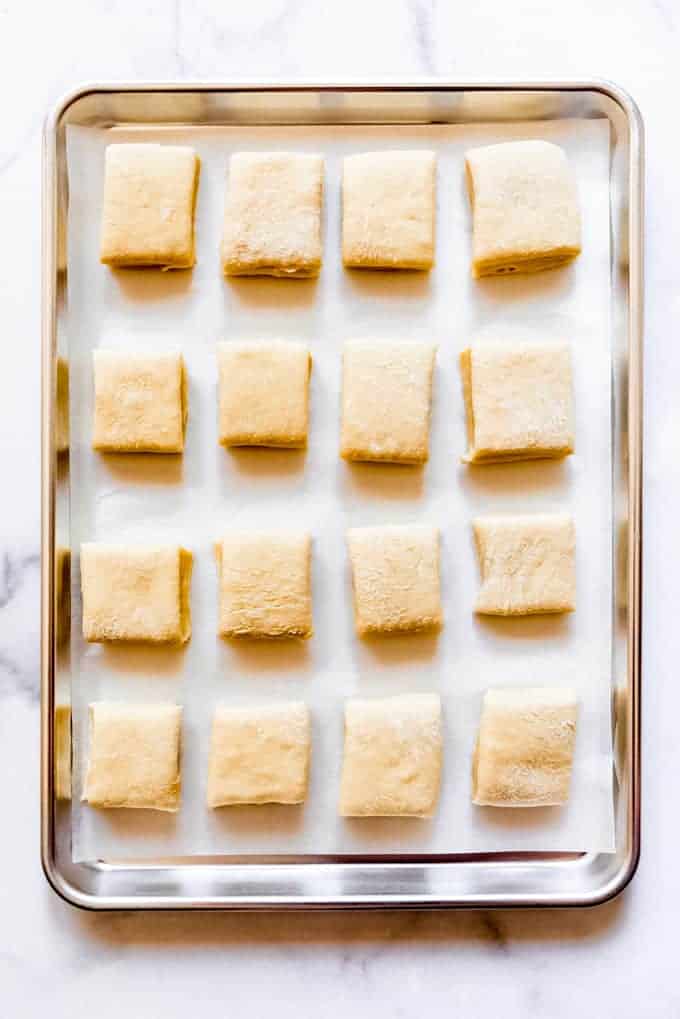 an overhead view of dough squares on a baking sheet