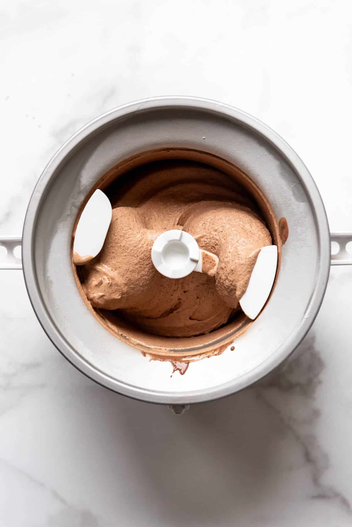 A KitchenAid ice cream bowl attachment filled with homemade chocolate ice cream.