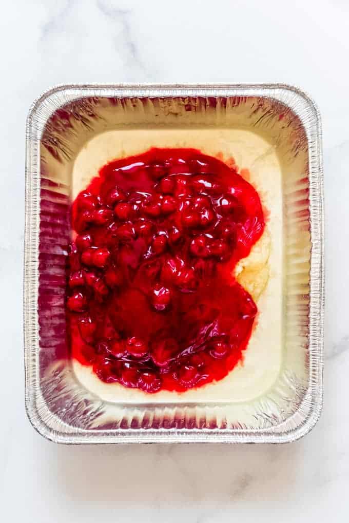 cherry pie filling and crushed pineapple in a disposable pan