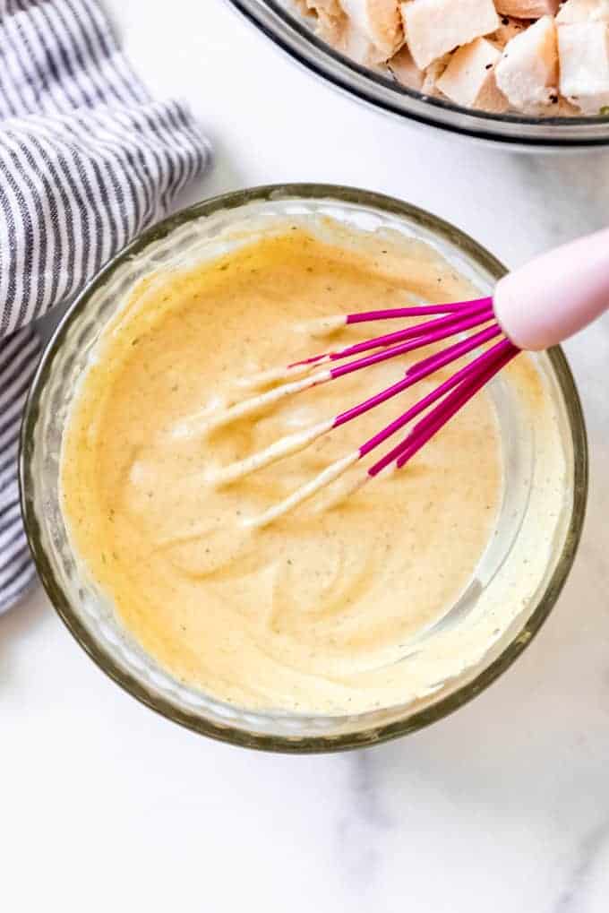 a bowl of whisked together curry sauce for the chicken salad