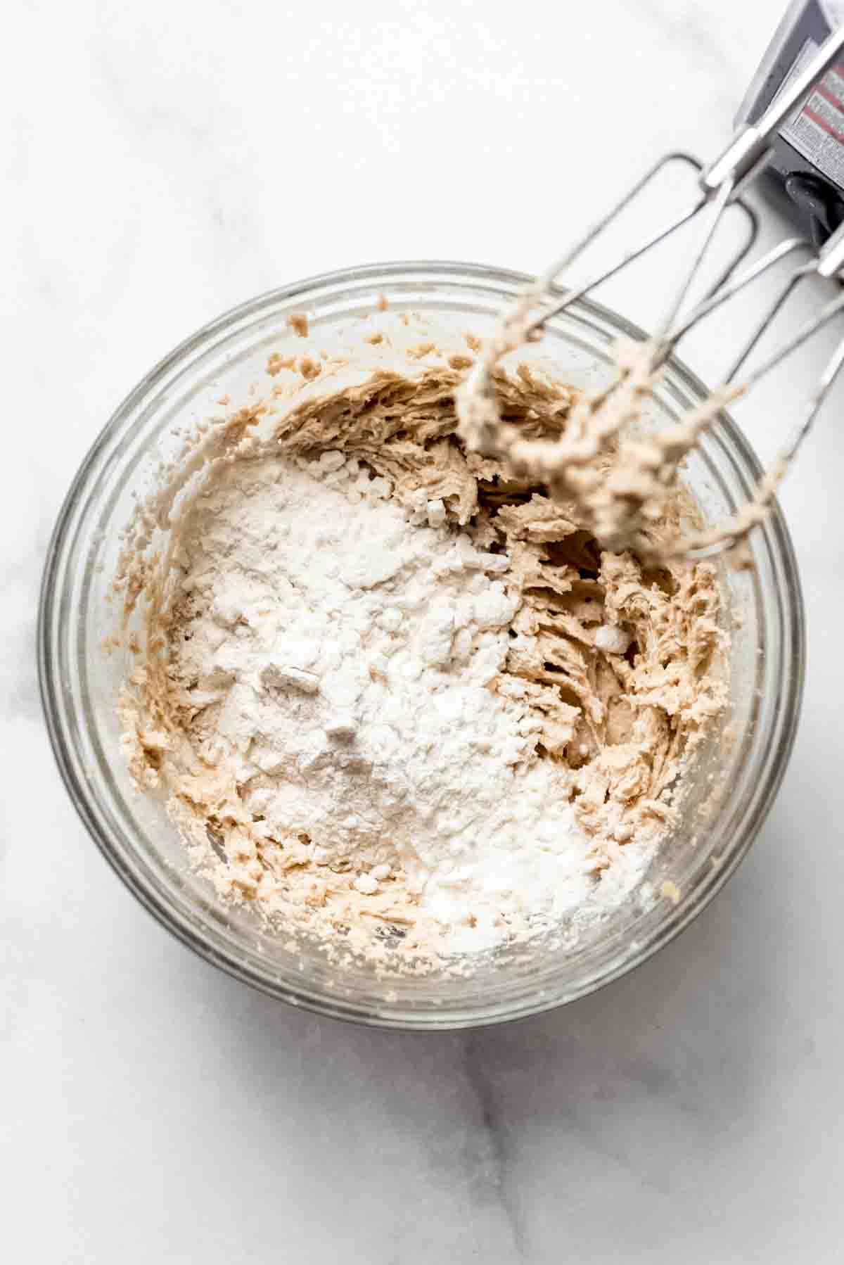 Adding flour and ingredients to the bowl of cookie dough