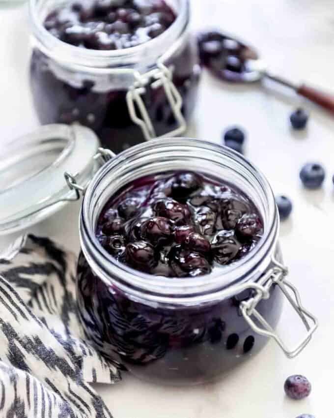 Two glass jars of homemade blueberry pie filling.