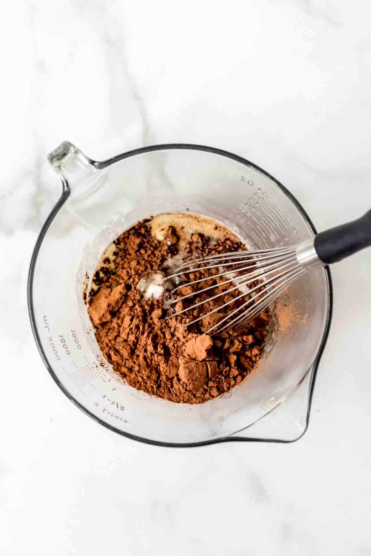 a bowl of brownie mix being whisked together in glass bowl