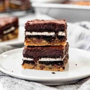 Slutty brownies stacked on a white plate.