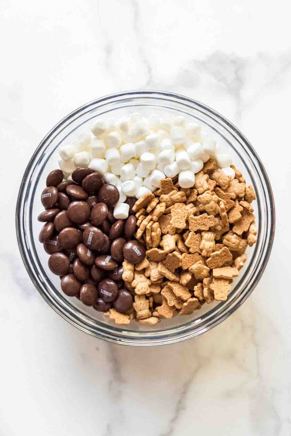 Combining Hershey's Drops, Teddy Grahams, and marshmallows in a bowl.