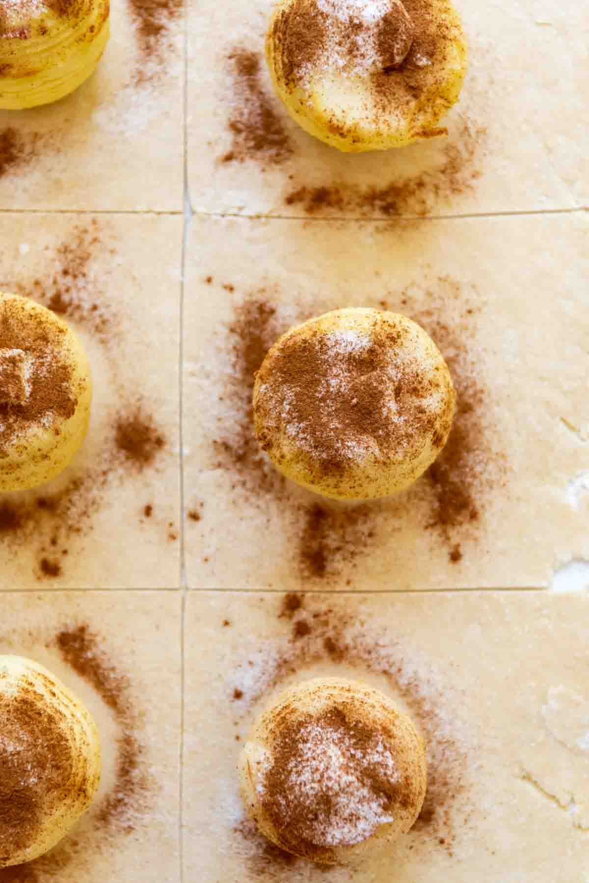 Apples sprinkled with cinnamon and sugar on pastry dough.