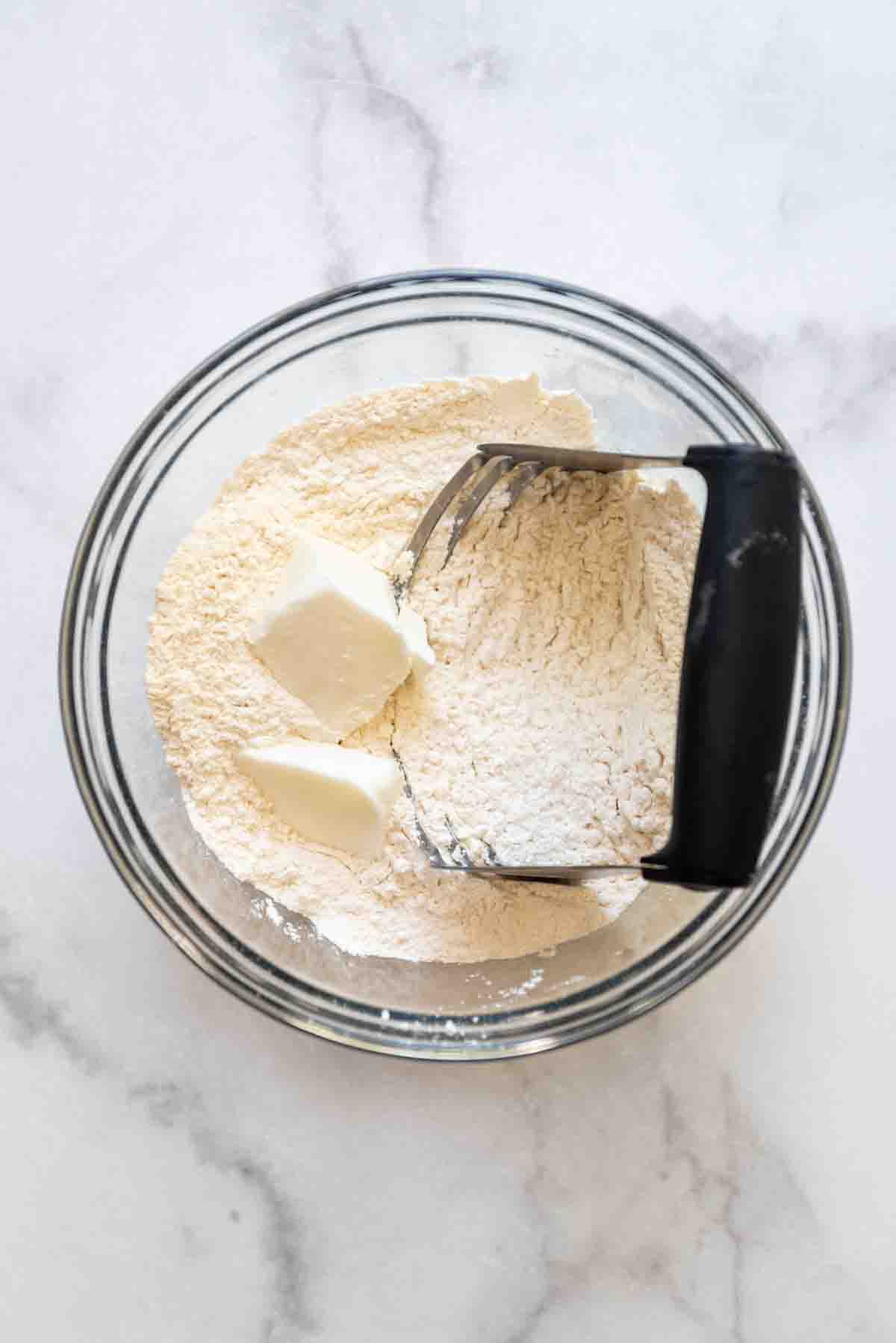 butter about to be cut into flour with a pastry cutter