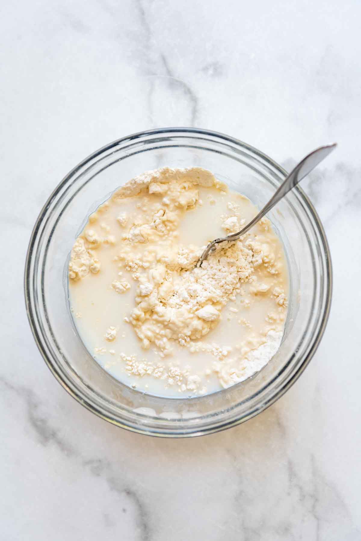 a bowl of mixed ingredients together in a glass bowl with a fork