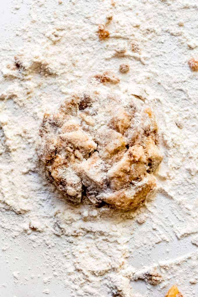 Apple fritter dough on a floured surface.