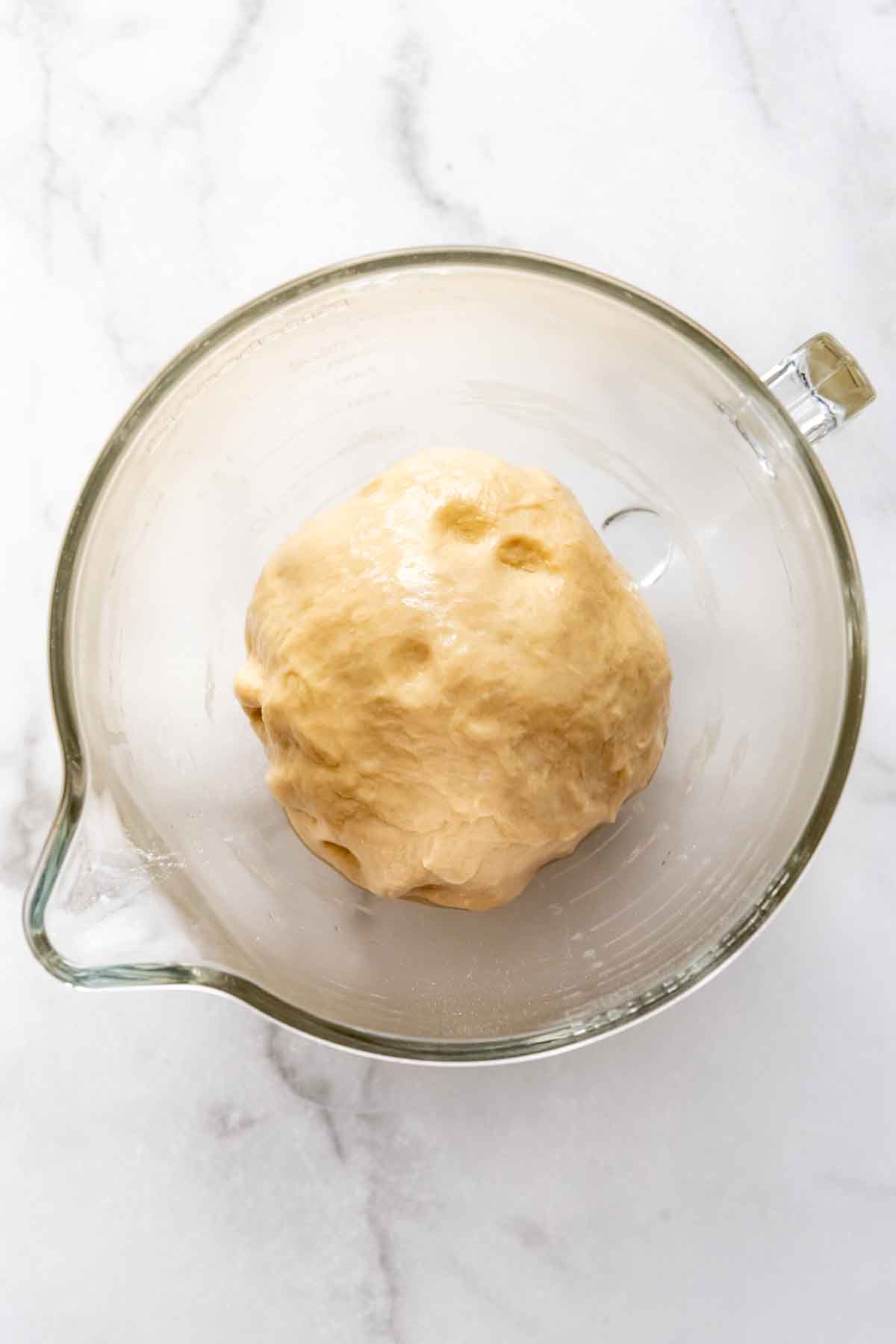 Kneaded dough in a glass bowl.