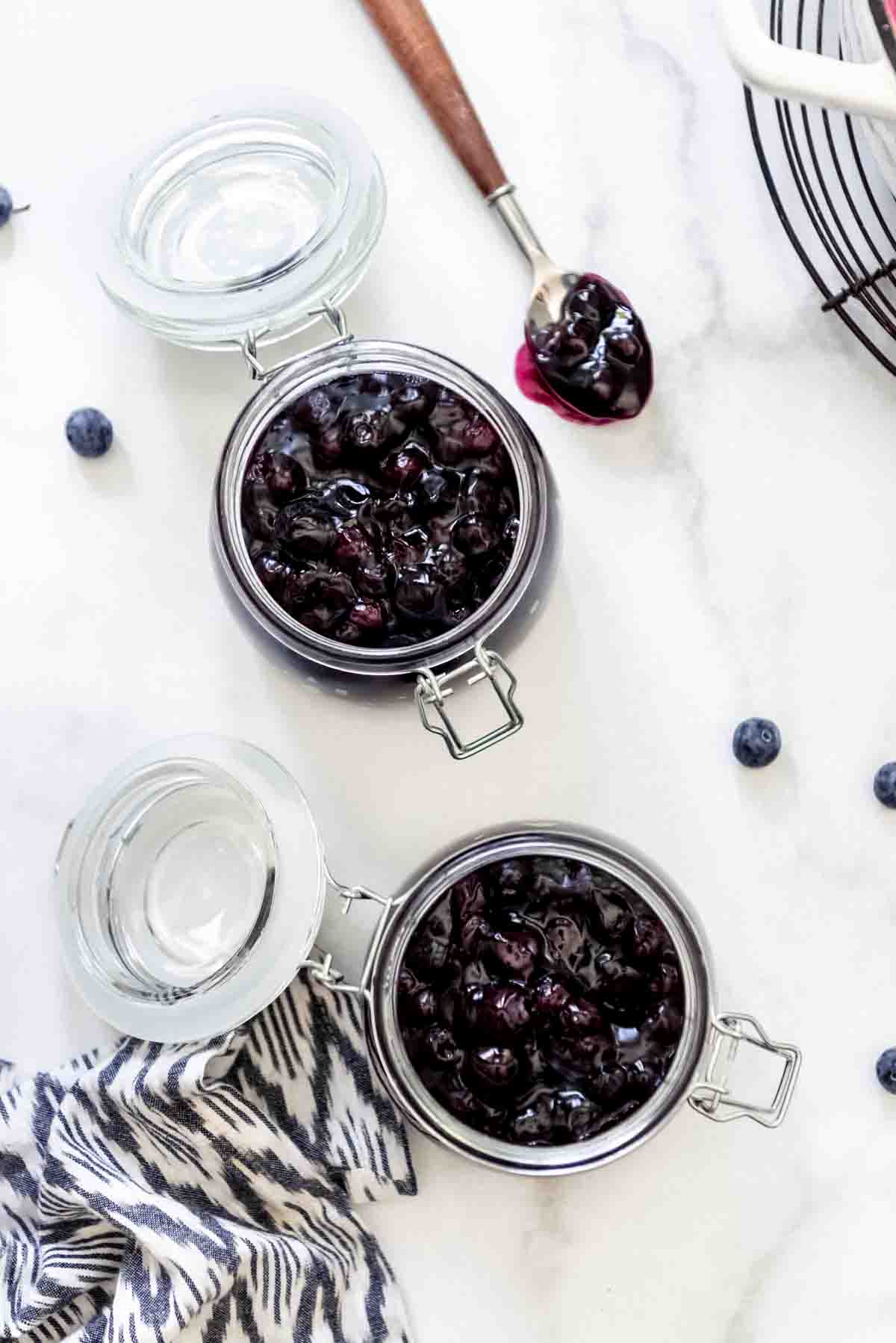 An overhead image of two jars filled with homemade blueberry pie filling.