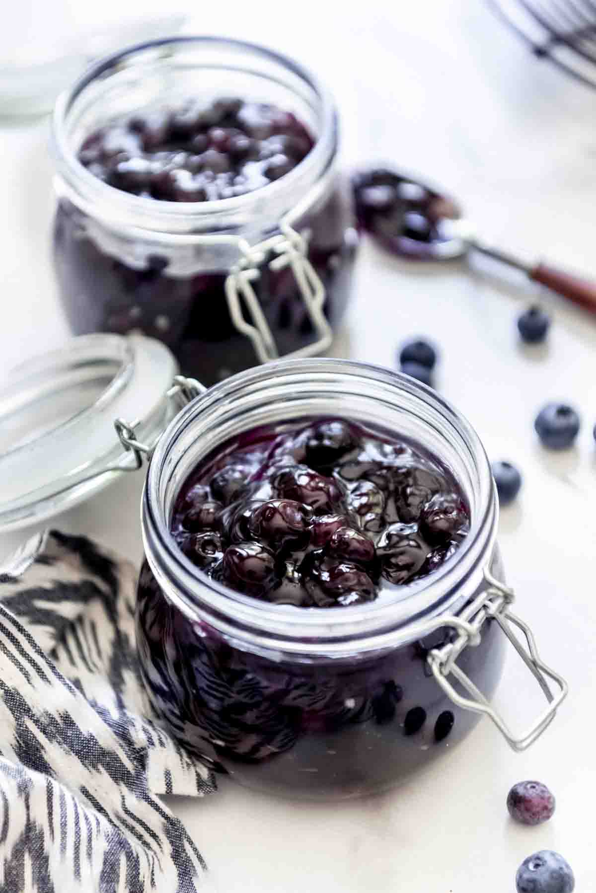 Two glass jars of homemade blueberry pie filling.