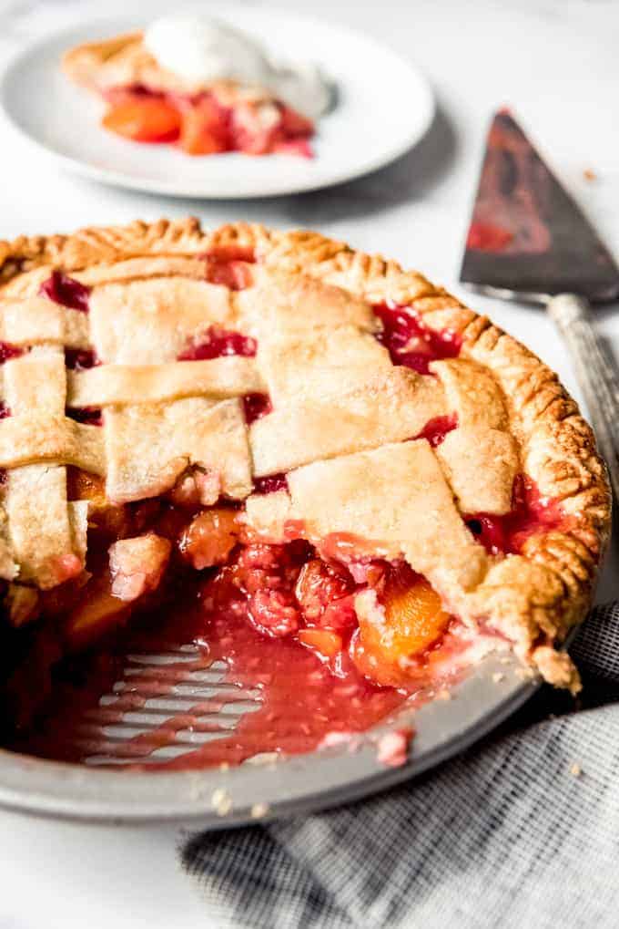 A sliced raspberry peach pie in a metal pie plate.