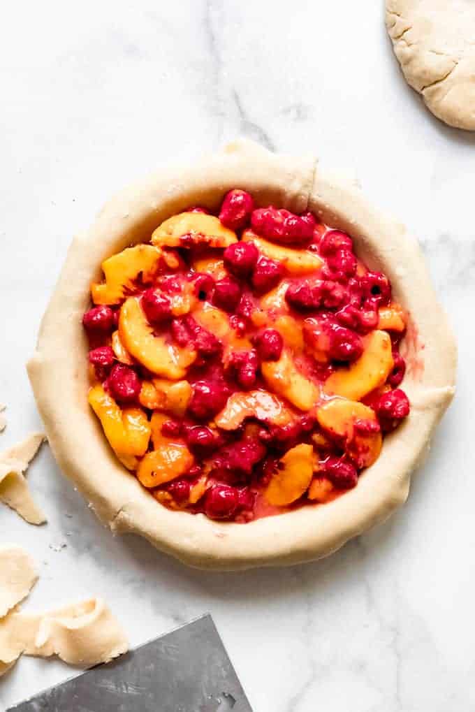 Raspberry peach pie filling inside a pie crust