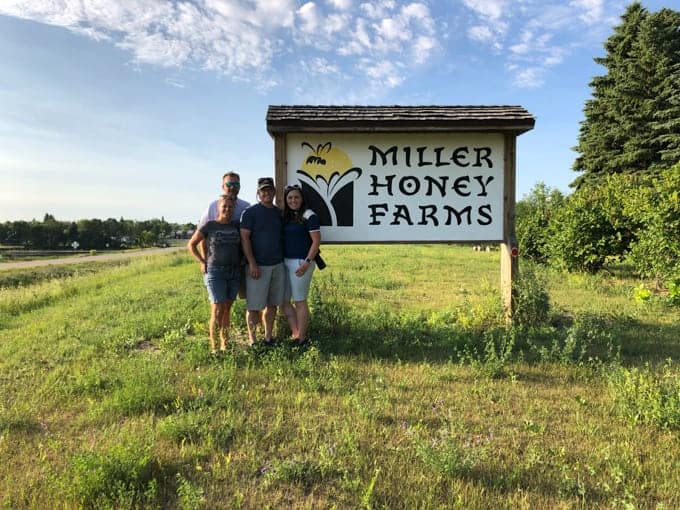 Two couples in from of the Miller Honey Farms sign in North Dakota.
