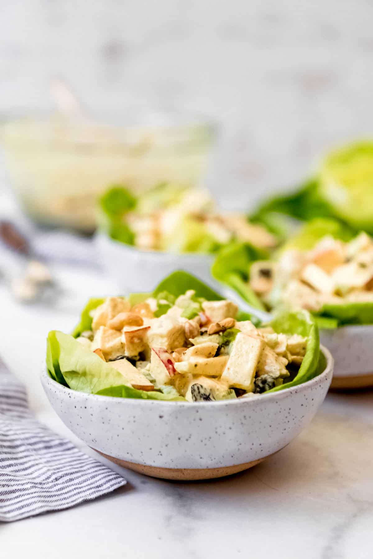 Curried chicken salad in bowl with greens.