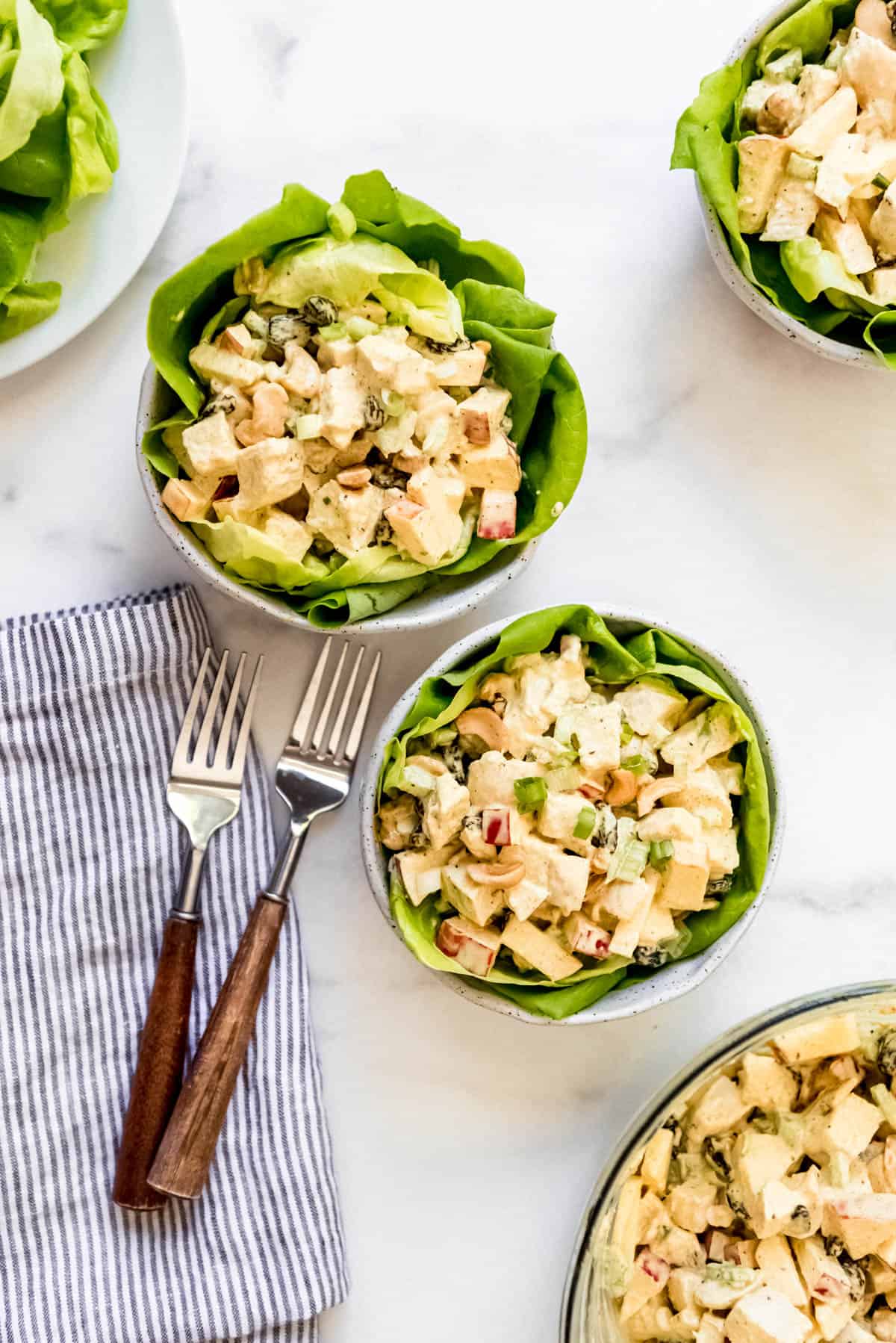 Overhead view of curried chicken salad served in bowls of butter lettuce.