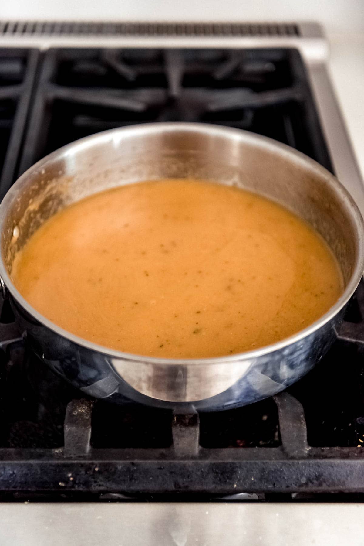A pan on a stove with homemade gravy.