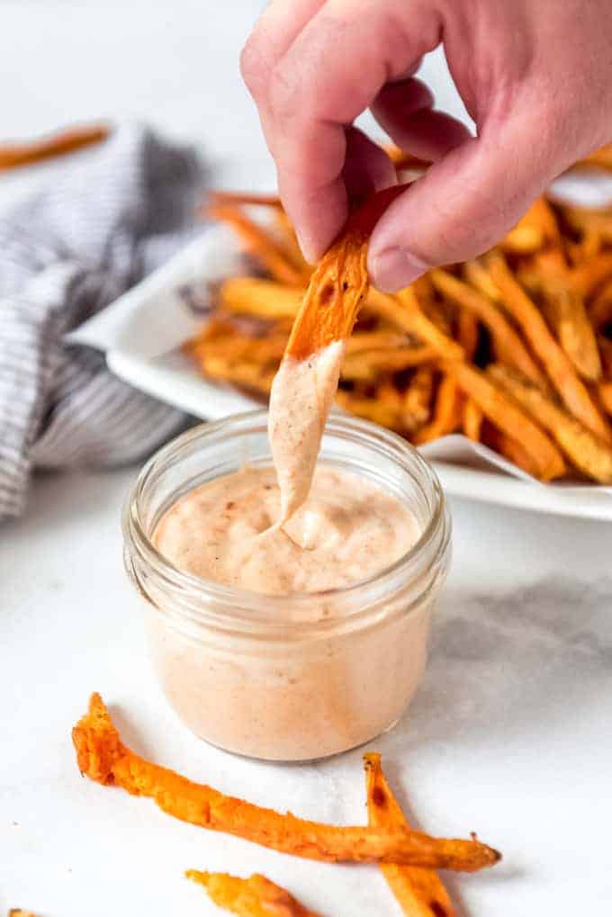 Blooming onion sauce in a small mason jar with sweet potato fries