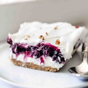 A slice of creamy blueberry delight dessert on a plate.