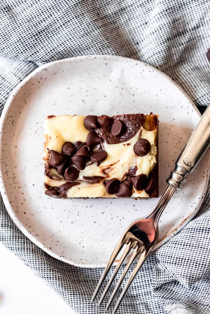a slice of cream cheese brownie on a plate with a fork