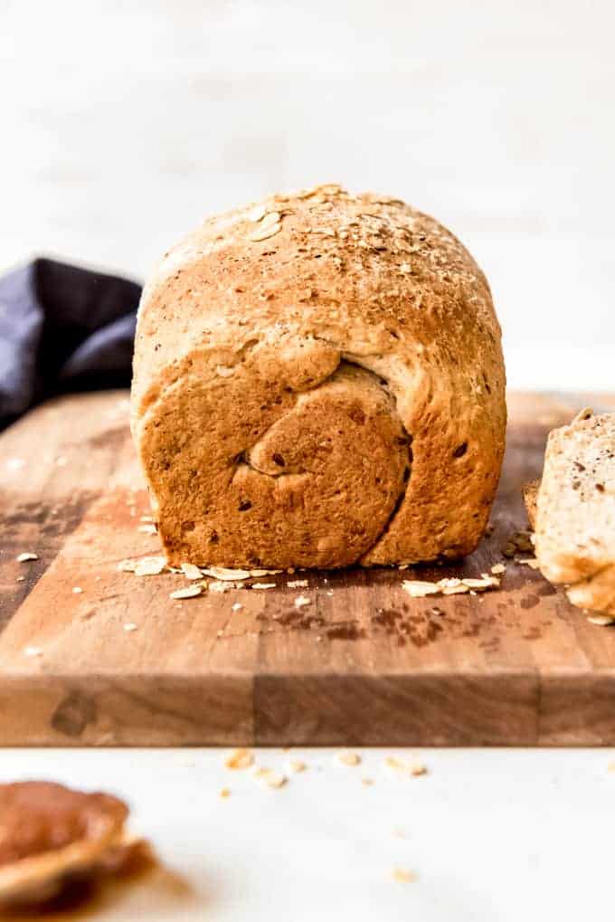 A loaf of multigrain bread on a cutting board.