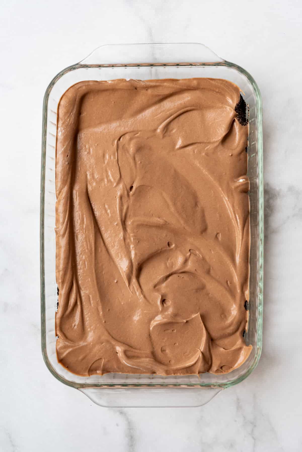 A layer of chocolate pudding in a glass baking dish.